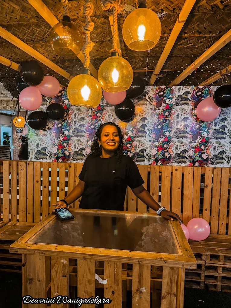 A guest smiling at a table decorated with balloons