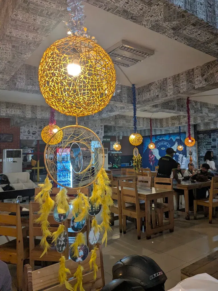 Woven globe lamps and a yellow feathered dreamcatcher above the dining area
