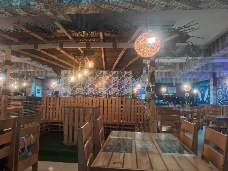 The Hogwarts Cafe dining hall with pallet-wood tables and hanging woven lamps
