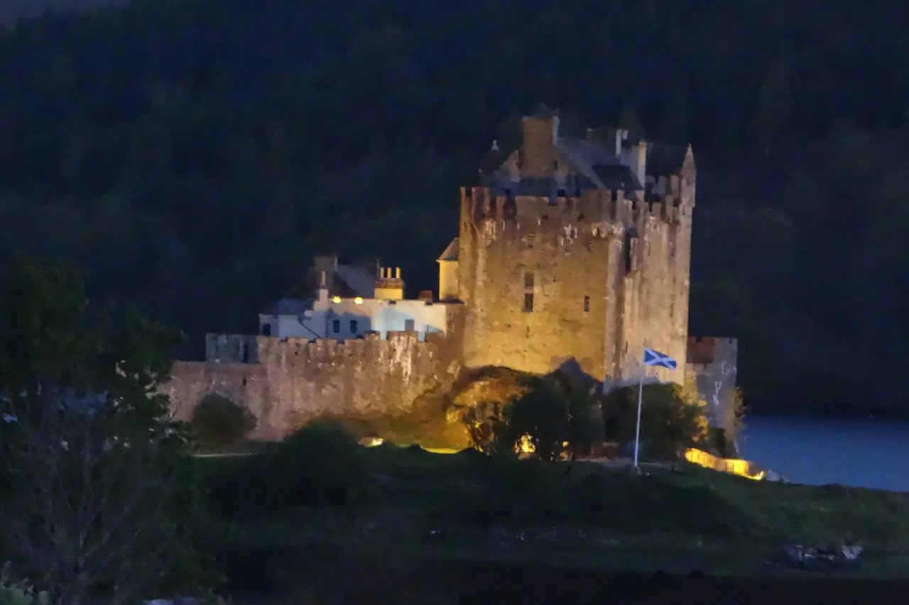 A lit castle reflected in a Highland loch at night